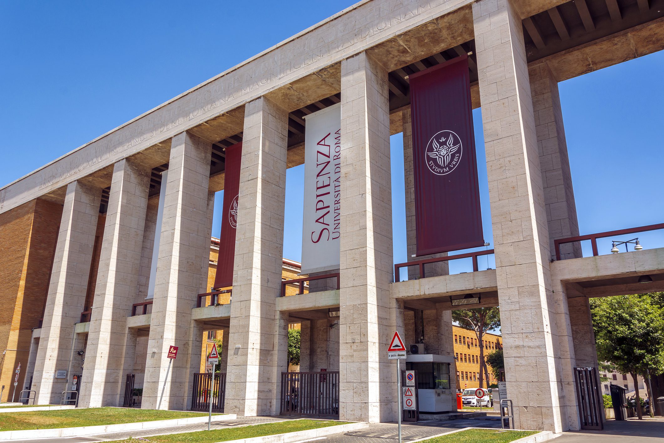 Exterior view of a modern building with tall columns and banners.