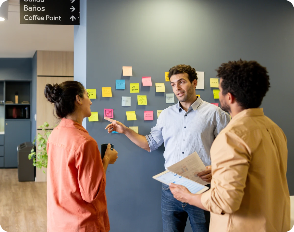 Office team discussing project with sticky notes